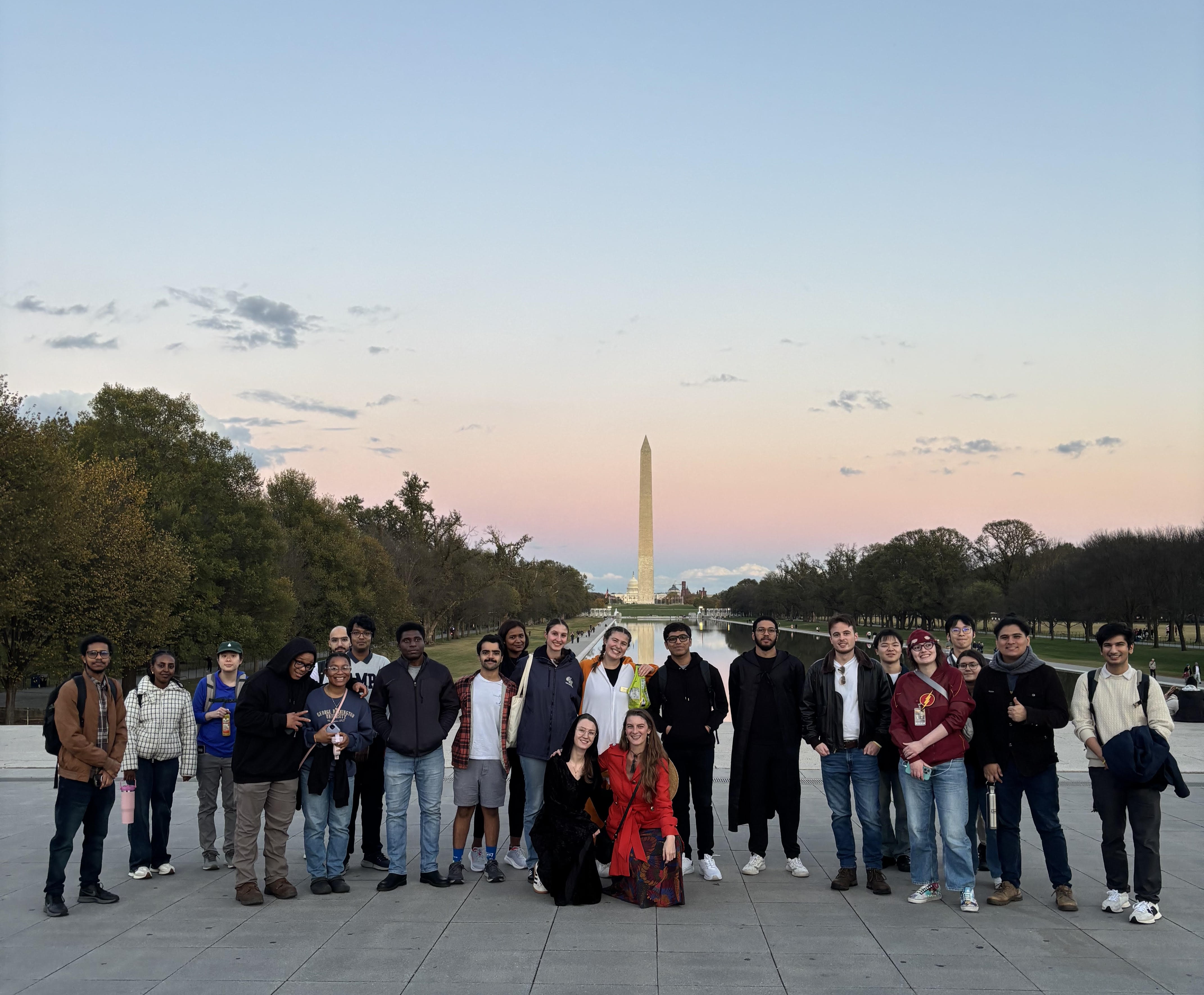 Graduate students taking a pic in front of the reflection pool
