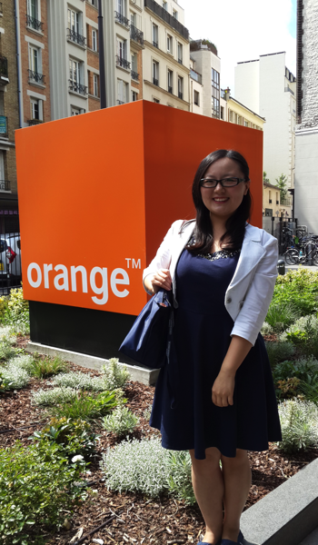 Yuxuan standing in front of orange TM sign