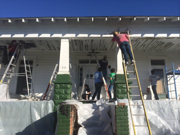 someone on ladder fixing up on house